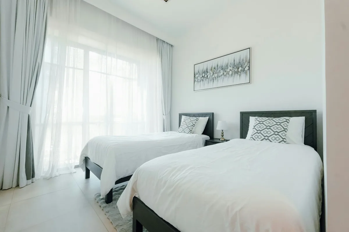 Phòng ngủ thứ hai có hai giường đơn trải lanh trắng
