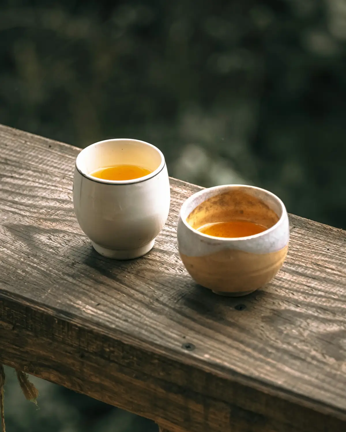 Chén trà thảo mộc bằng gốm mộc trên hiên gỗ buổi tối